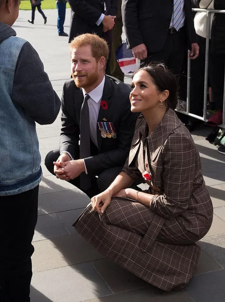 Meghan and Harry greet fans in Wellington.

Meghan is wearing a Karen Walker Banks plaid trench, with her favorite Sarah Flint pumps. Photo: Getty 