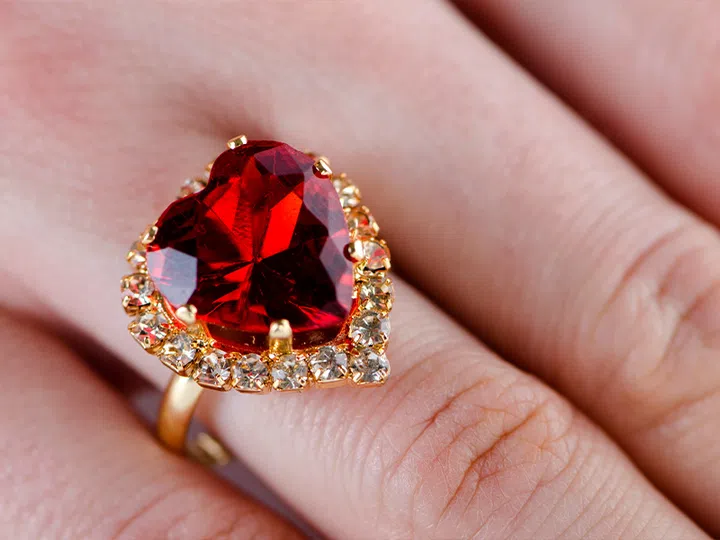 coloured gemstone engagement rings | heart-shaped garnet ring on finger