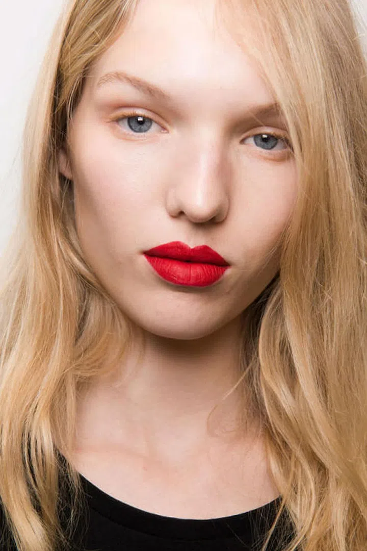 Makeup artist Lynsey Alexander used gloss on the eyes, but not on the lips, at Mary Katranzou. Instead, she applied a few different shades of "pumped-up" red or pink matte lipstick for the ultimate in texture variation.