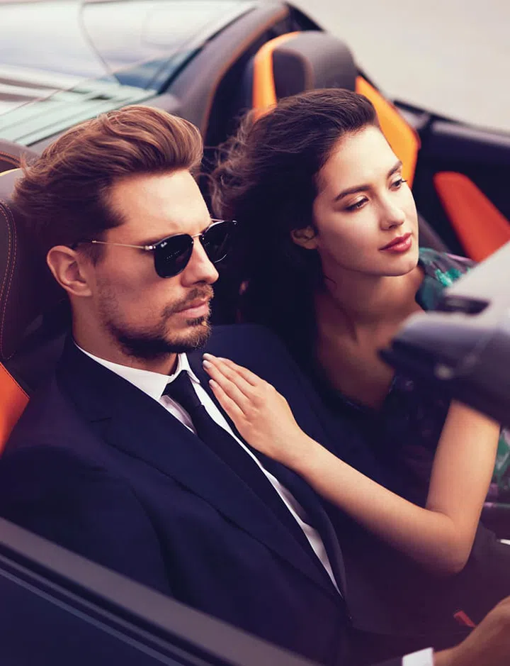 (On her) Dress, CH Carolina Herrera. (On him) Jacket; shirt; pants, CH Carolina Herrera. Tie, BOSS. Sunglasses, Ray-Ban