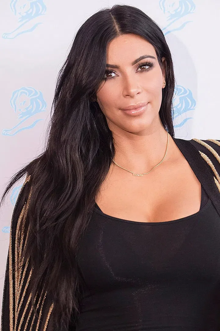 Kim Kardashian's sleek center part adds drama to her long piecey strands.