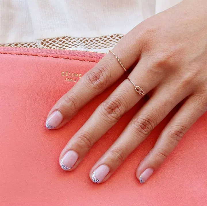 To pull off sparkly tips in a sophisticated way, pick a sheer base color and keep the length short and the shape round.  
@paintboxnails