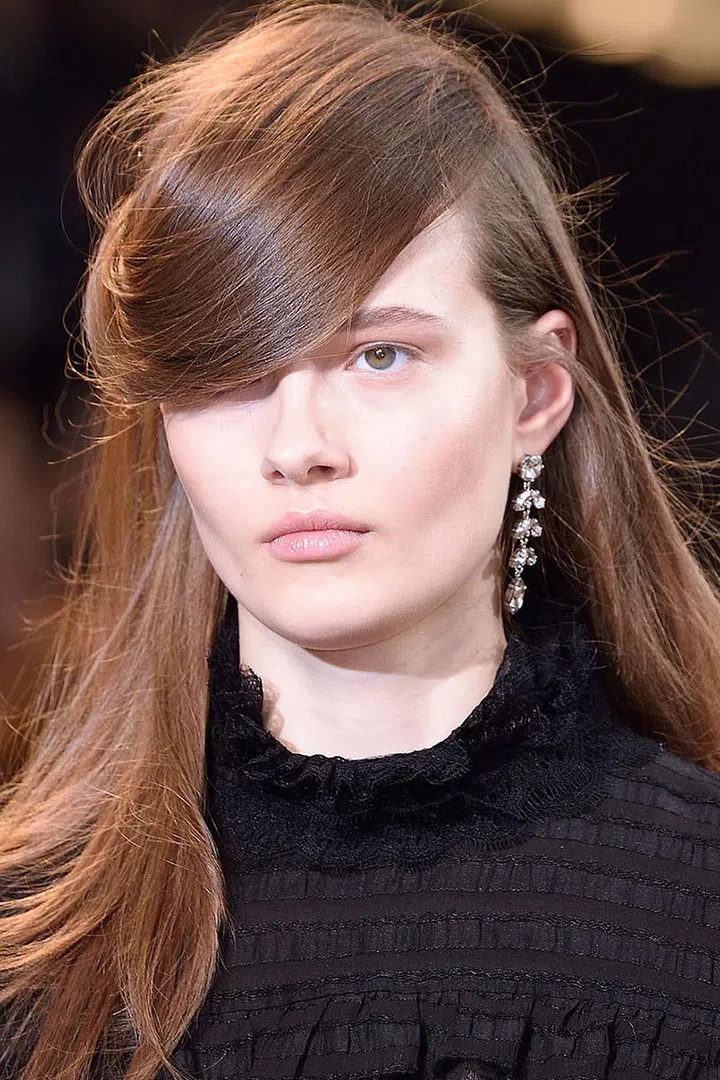 Isabel Marant hair is usually synonymous with Parisian hair—that is, easy, effortless, nothing. This season, however, Marant "wanted more of a statement," said Guido as he styled three different looks—quiff chignons with a fifties feel, and soft blowouts with heavy sideswept bangs that worked with the more eighties-themed collection. The key is to use "just a little bit of hairspray," especially on curls; Guido misted water from a spray bottle to keep things feeling light and soft instead of shellacked.