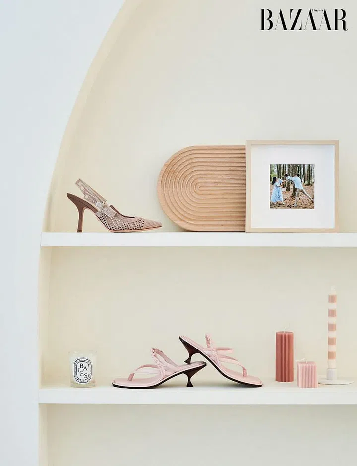 A Dior slingback and Tory Burch heeled sandals on arch-framed shelves. 