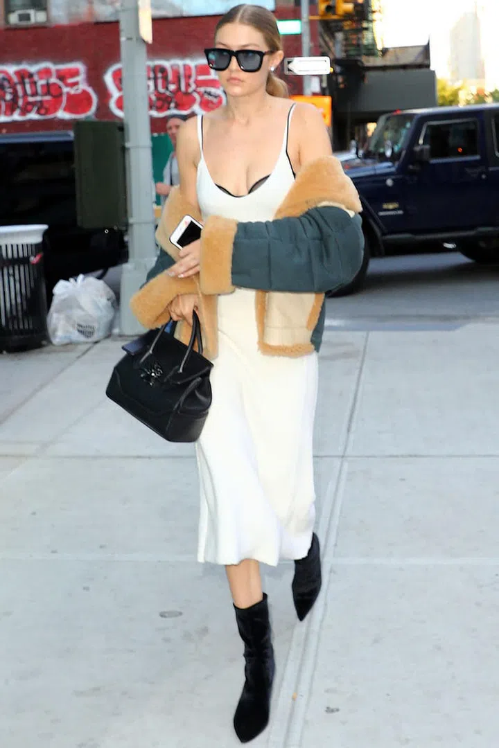 In a Victoria Beckham midi slip dress with a draped shearling coat and the perfect black accessories—oversized shades, velvety booties and a Versace handbag. Photo: Splash