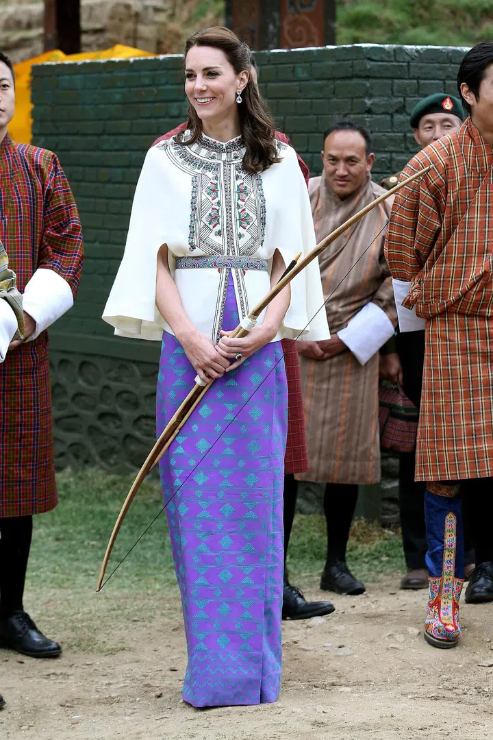The duchess sports a bright purple-blue dress under a Paul & Joe embroidered tunic during an Bhutanese archery demonstration on their trip to the Himalayan nation.