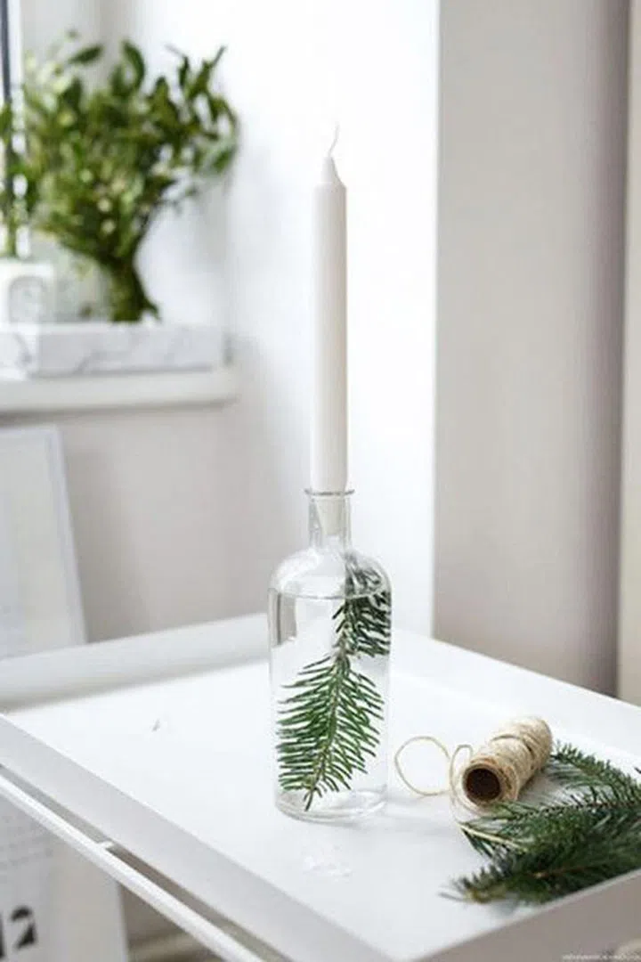 Take any extra trimmings off your tree and put them to good use with a small vase of water and a long-stem candle.