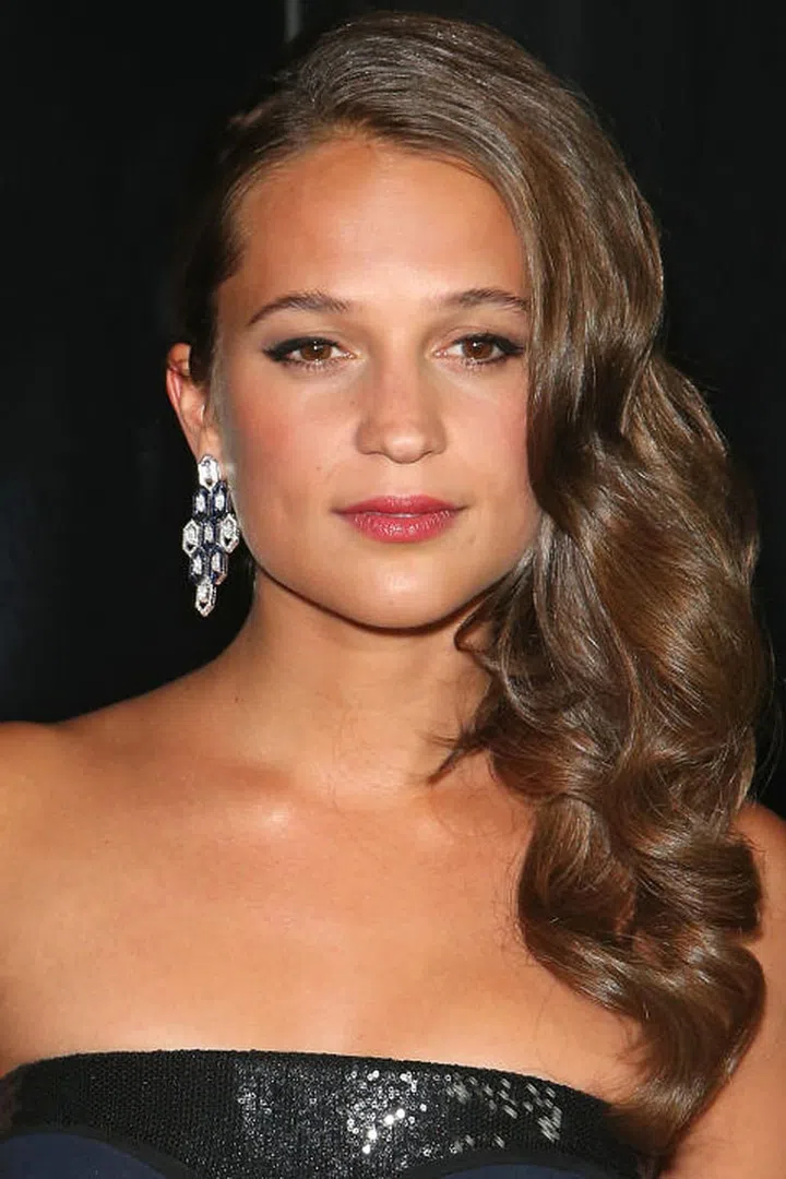 Vikander serves up Old Hollywood glamour with over-the-shoulder waves and a sleek, side-parted crown. Photo: Getty