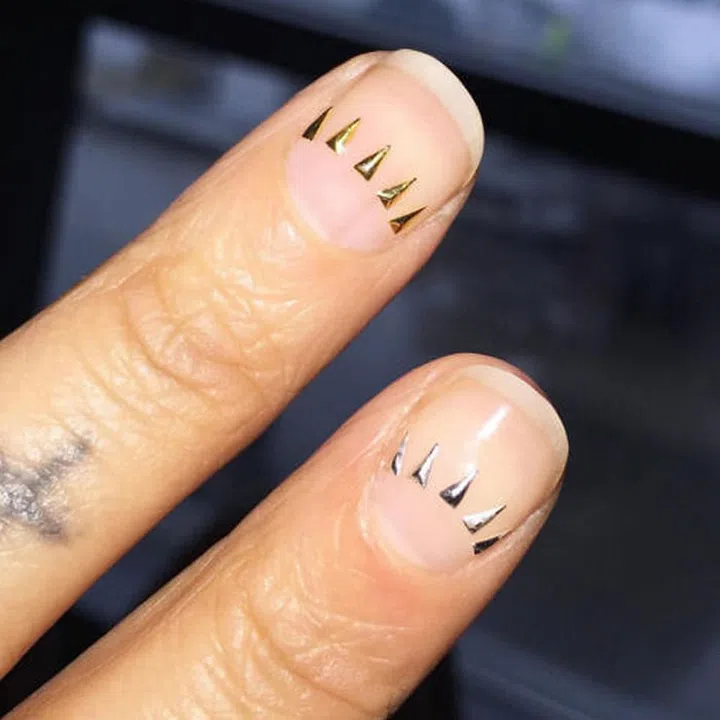 Alicia Torello (@aliciatnails) glued a crown of tiny gold triangles along the center of the nail bed.