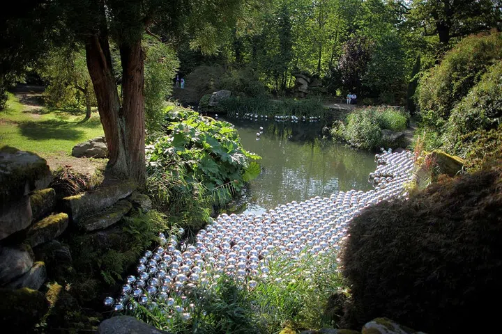 The queen of the polka-dot, Yayoi Kusama was a significant force of the avant-garde art scene in the 1960s and continues to push the boundaries of art-making—even into fashion through her recent collaboration with Louis Vuitton. Her "happenings" during the 1960s were groundbreaking, in particular Narcissus Garden of 1966, which the artist performed on the world stage at the Venice Biennale. Funded by fellow artist Lucio Fontana, Kusama gathered 1500 silver balls—three-dimensional polka-dots—on a lawn and offered them for sale to visitors for 1,200 Lira ($2 dollars) each, as a critique of the commercialism of the art world.
Pictured: Narcissus Garden on display at Chatsworth House in Chatsworth, England in 2009