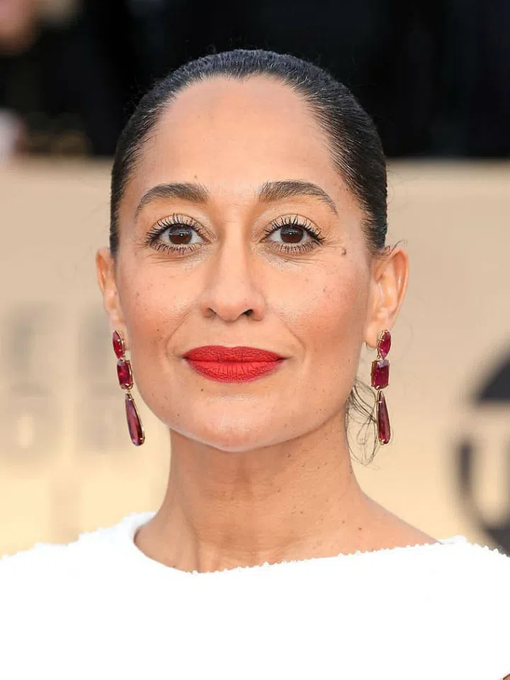 Her white dress and red earrings ensemble with matching lipstick? Totally regal.