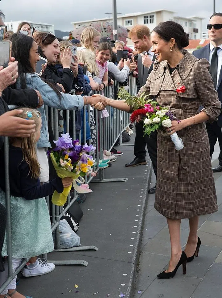 Meghan and Harry greet fans in Wellington. They even stop to take a selfie with two young fans, breaking royal protocol in the process.

Meghan is wearing a Karen Walker Banks plaid trench, with her favorite Sarah Flint pumps. Photo: Getty 