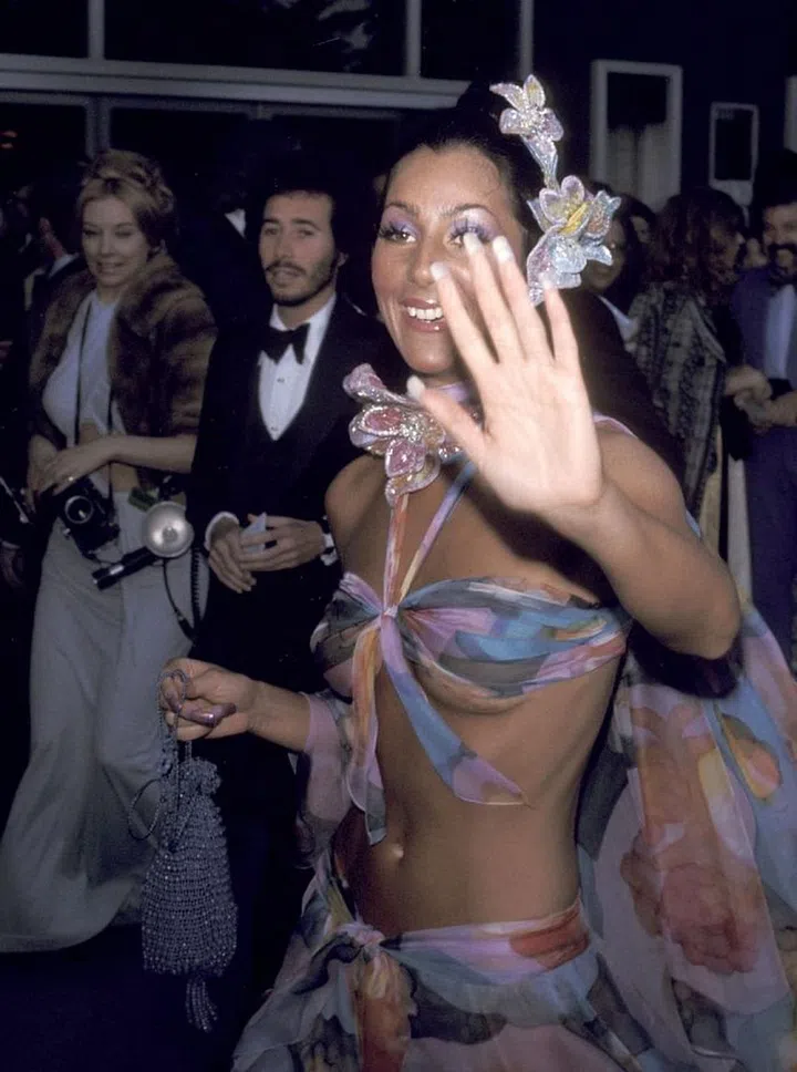 The following year, Cher hit the 46th Academy Awards in another Bob Mackie-designed look that showed off her killer abs. This time, the singer opted for a coordinating top and skirt made out of a colourful, thin fabric that some may consider a beach sarong. For Cher, however, it was transformed into eveningwear when paired with an ornate flower headpiece and choker. Don't forget the matching eye shadow and nails. Photo: Getty 