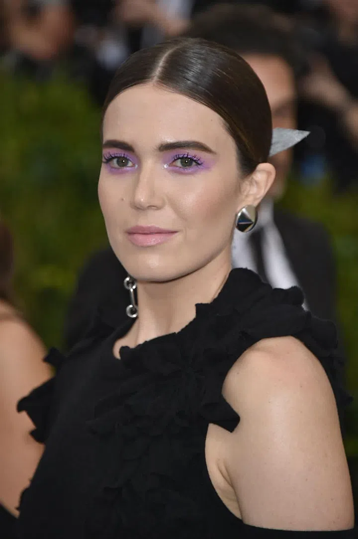Moore kept the girl-next-door look on her vanity, and took a more daring avant-garde beauty look. Her almost bare makeup was a canvas for eyes that were artfully swiped with violet eye shadow and framed with strong brows (Photo: Getty)