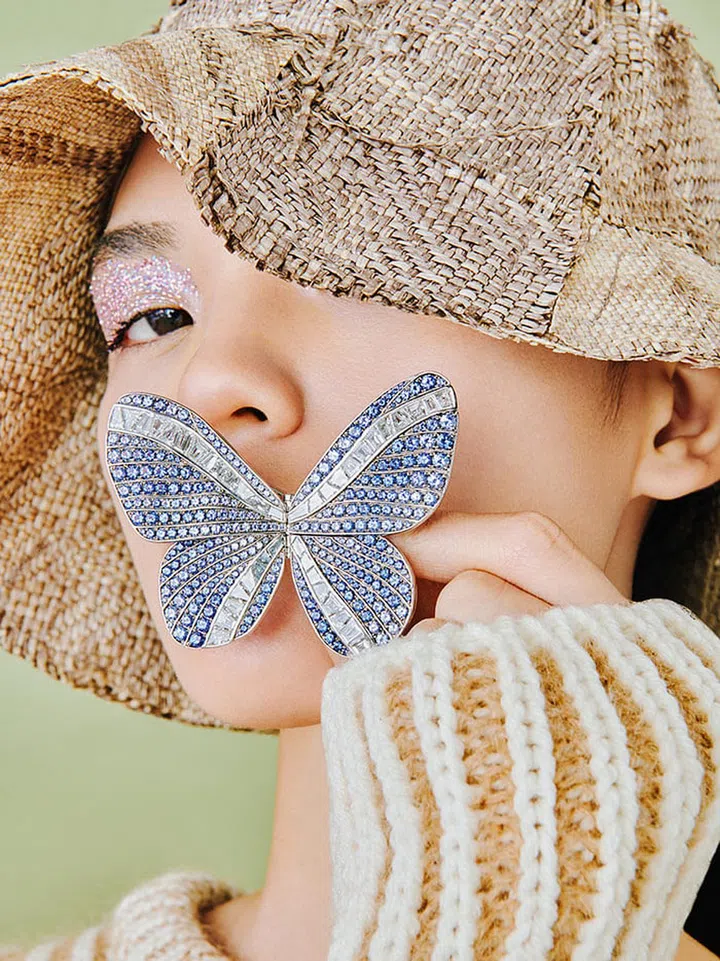 White gold, sapphire and diamond brooch. Knit sweater, Chloé.