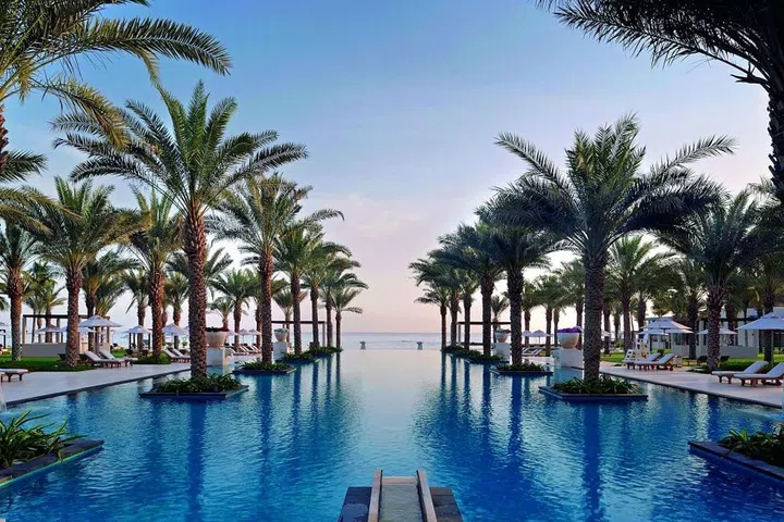 This hidden gem is tucked away between the Al Hajar mountain range and the Sea of Oman. The Al Bustan Palace offers five separate outdoor swimming pools, one of which spans a sizable chunk of the resort between the hotel and the private, white sand beach. The 50-meter pool is ringed by dozens of palm trees and offers near-infinite views of the Sea of Oman. "During the day, it provides a fantastic family playground with fountains flowing on each side, while offering endless views on the sea line," says general manager Katrin Herz. "And at night, the fire pots and palm trees framing the pool make it a perfect backdrop for a romantic evening." 