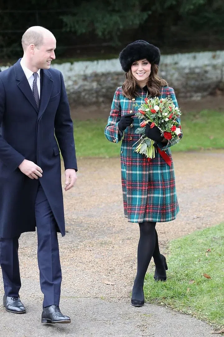 Kate was festive in a tartan Miu Miu coat and furry hat, while William opted for all navy. Photo: Getty 