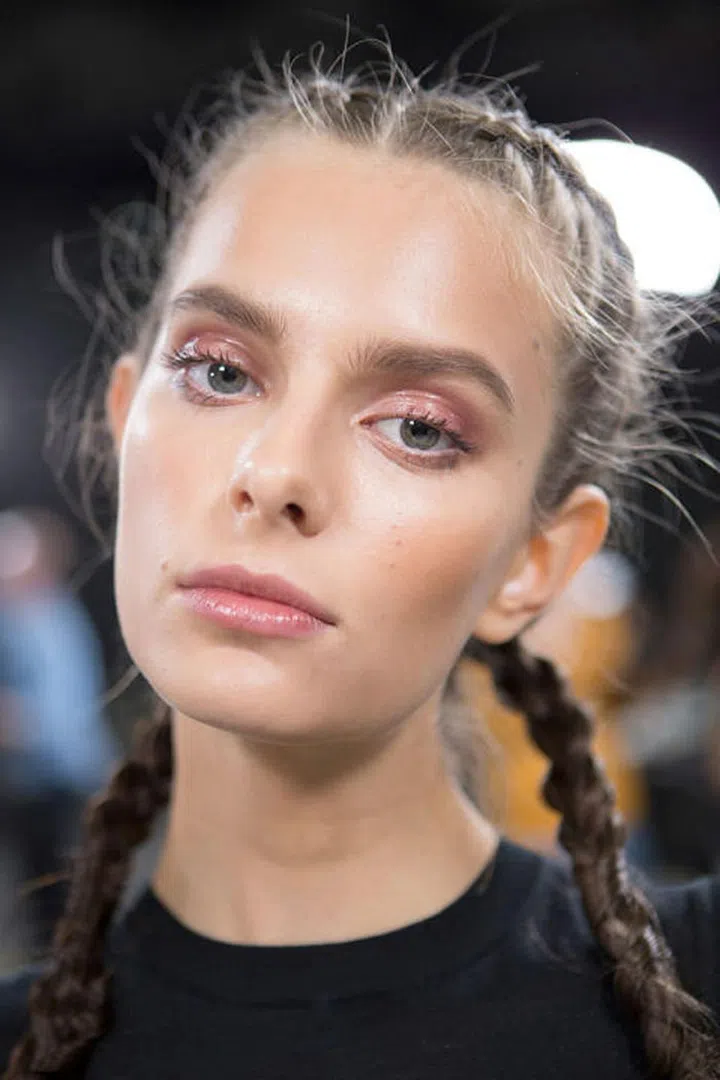 The Look: Vagabond Beauty
How-To: "The inspiration was a traveler, and he wanted a burnished glow that was kind of easy," said makeup artists Linda Cantello. "We've done the easiest makeup ever." That included a little bit of foundation, blush along the cheekbones and toward the temples, filled-in brows, mascara on both sets of lashes, and then the same lipstick applied on the eyes and the lips (Armani Rouge D'Armani Sheer in Far Away). Compared to the hair, it was quite easy. Hairstylist Rudi Lewis spent days weaving over 300 braided extensions. The final look was a jumble of  five looped, fishtailed, and otherwise purposefully imperfect braids. "This girl has been away for a while. Her hair has been growing out, she's got braids," Lewis said backstage. "They're braids that have gotten a bit salty and messy." If that's what it takes to get braids this pretty, then count us in.