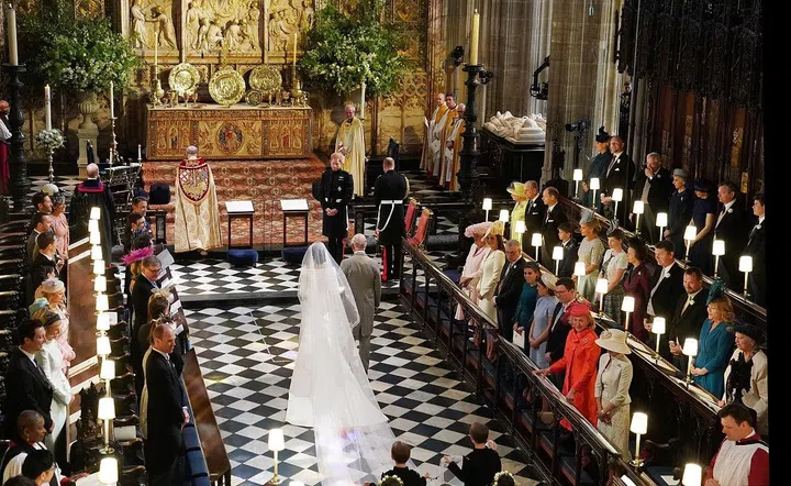 Prince Harry looks at his bride, Meghan Markle, as she arrived accompanied by Prince Charles