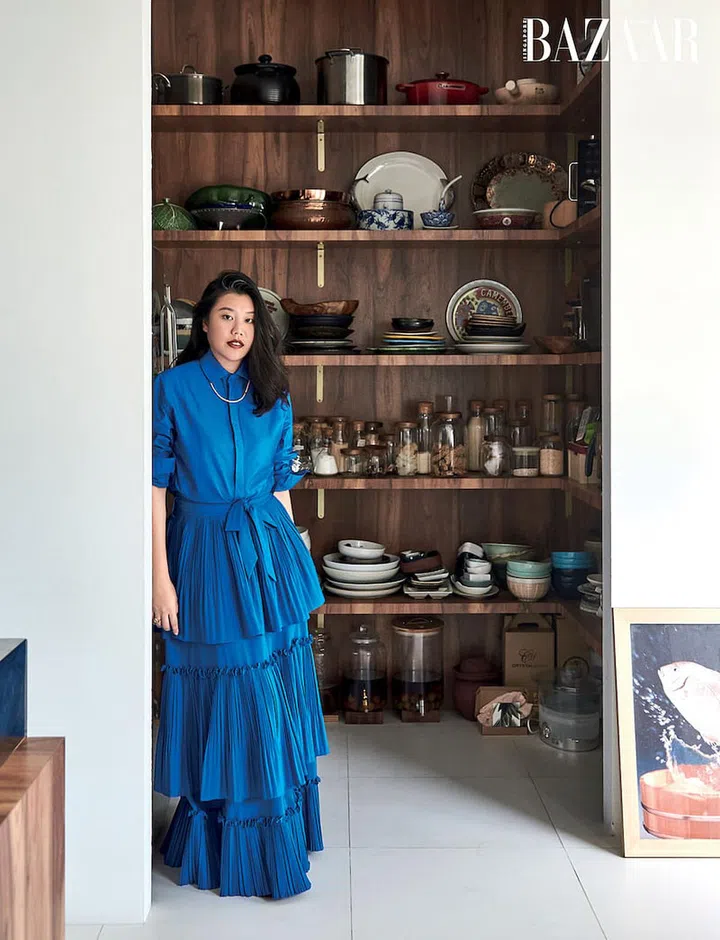 Wearing a In Good Company shirt, ASOS skirt and a gifted beaded necklace and ring, Tan stands in front of her favourite spot, a pantry that houses her beloved tableware. 