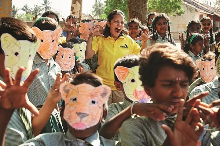 Krithi Karanth (centre) participates in a school workshop by Wild Seve, with children posing as wild animals.