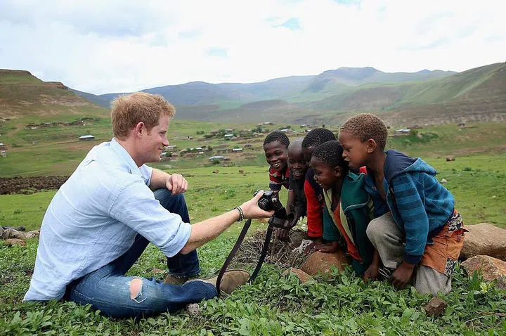 Prince Harry shows children a photograph he has taken during a visit to a night school for "herd boys" that was constructed by in Lesotho. Prince Harry was visiting Lesotho to see the work of Sentebale, the charity he c0-founded to provide healthcare and education to vulnerable children in the the South African nation.