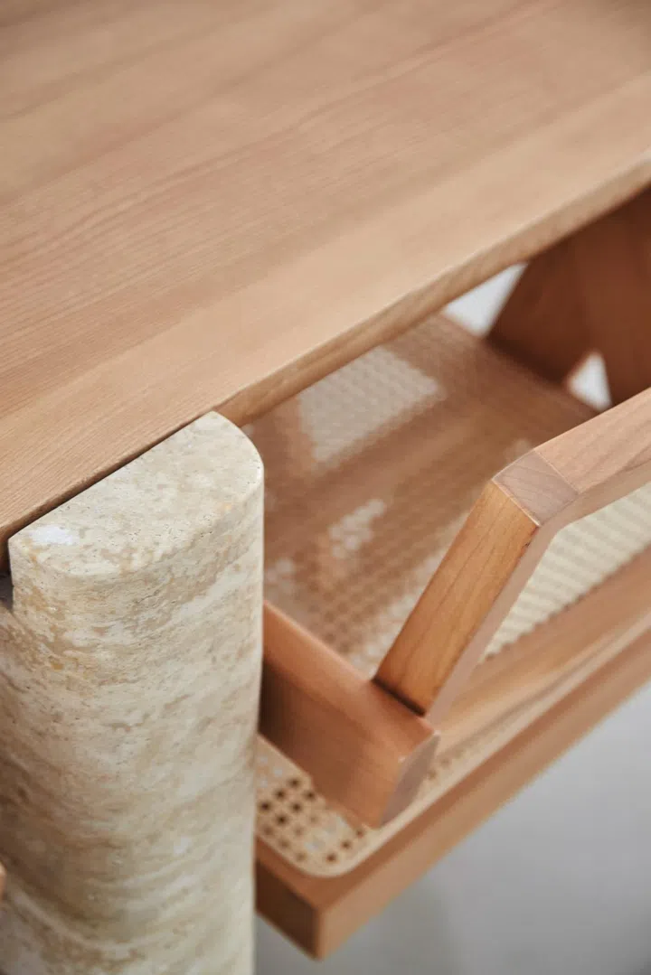 Wong’s custom dining table, made from travertine and wood, paired with wood and wicker chairs. Photo: Veronica Tay.