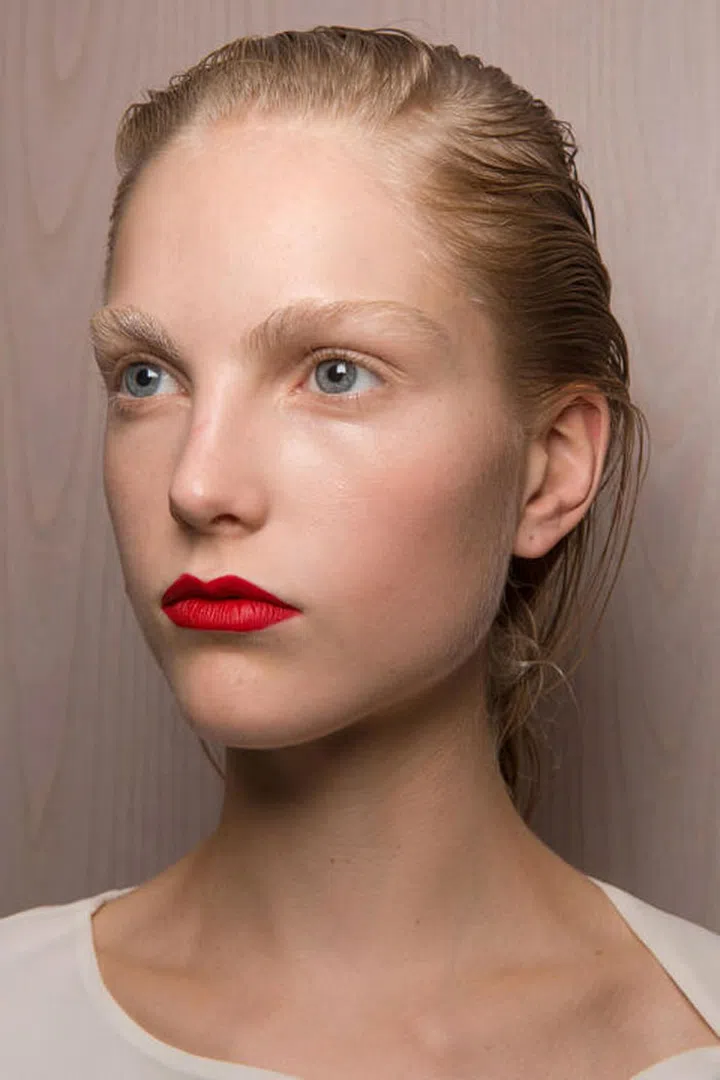 At Olivier Theyskens, the makeup was kept raw and bare other than a pop of a matte red lipstick.