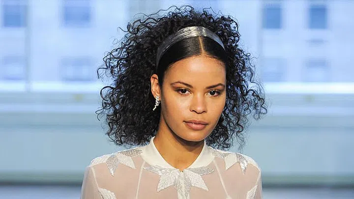 Make your curls pop by securing a metallic headband back along the middle of your head. By keeping the section by your hairline sleek and shiny, it makes the curls behind the headband look extra-luxe.