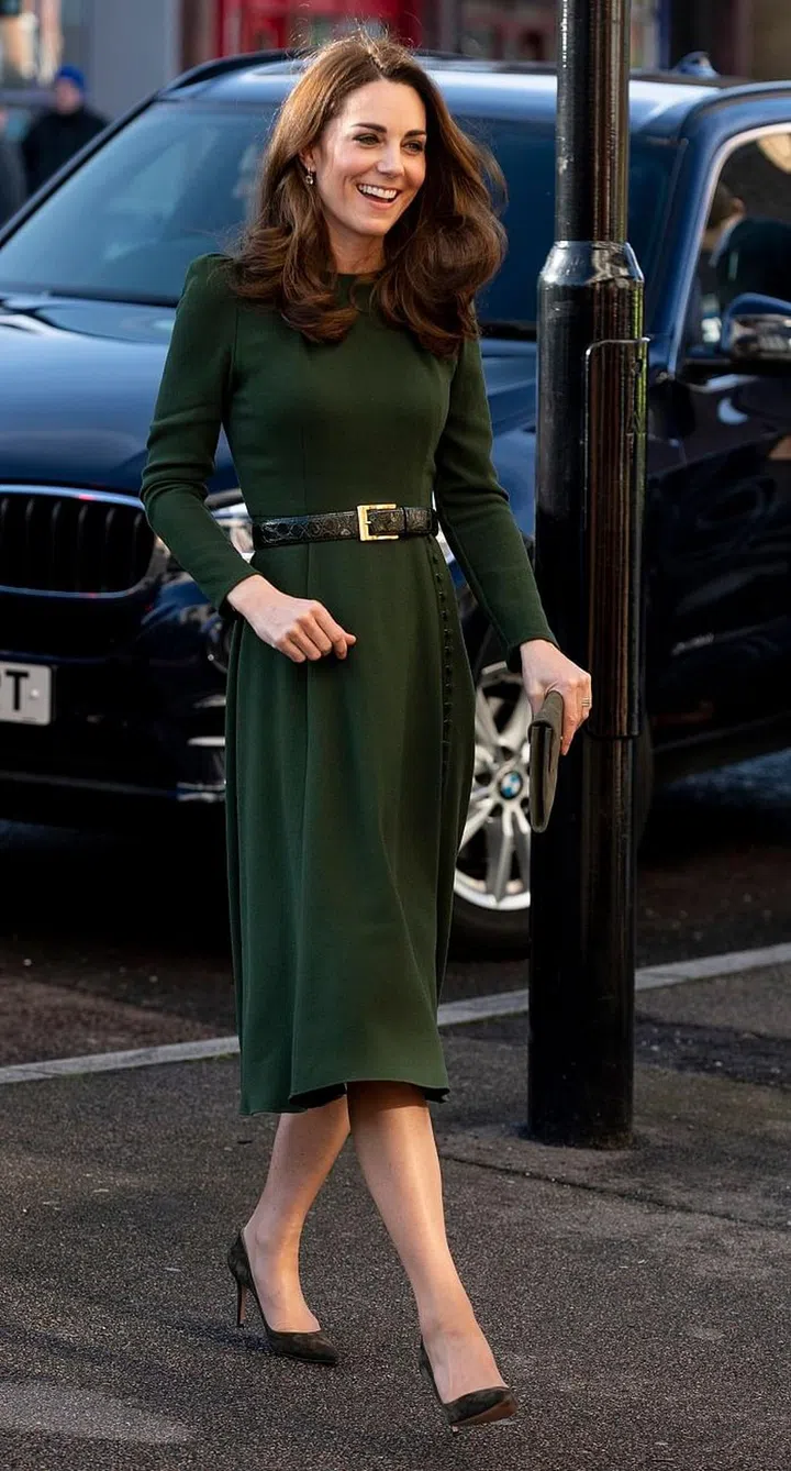 The Duchess attended the Family Action engagement in a bespoke forest green dress by Beulah London. She finished the look by cinching the dress with a leather belt and olive Gianvito Rossi suede pumps. 