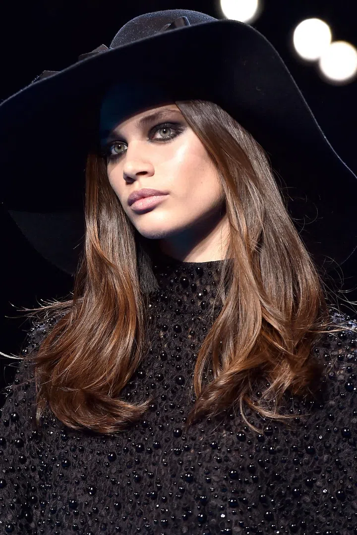 "It's a very rock-chic, moody feeling," said makeup artist Tom Pecheux of the overlapping black ovals, outlined by high-sheen liner, on the eyes at Elie Saab. He blended taupe blush across the entire lid to the end of the brow and just under the lower lashes for a large oval shape, then filled in an almond shape inside that with greasy black gel liner. On top of the gel, he tapped shimmery black pigment. "It's important the eyes look big, and to feel like there's a dark circle inside the taupe oval, otherwise it becomes a makeup commercial in the '90s," said Pecheux.