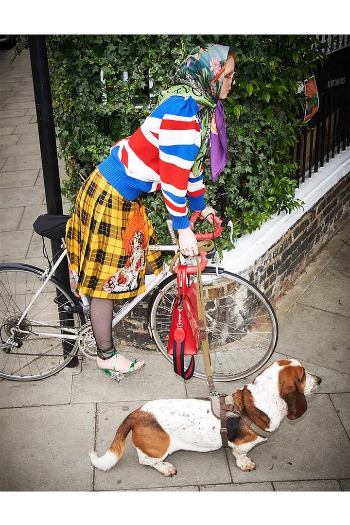 Knit sweater; embroidered wool skirt; silk scarf; acetate sunglasses; metal rings; leather bag; fishnet stockings; leather sandals, Gucci.