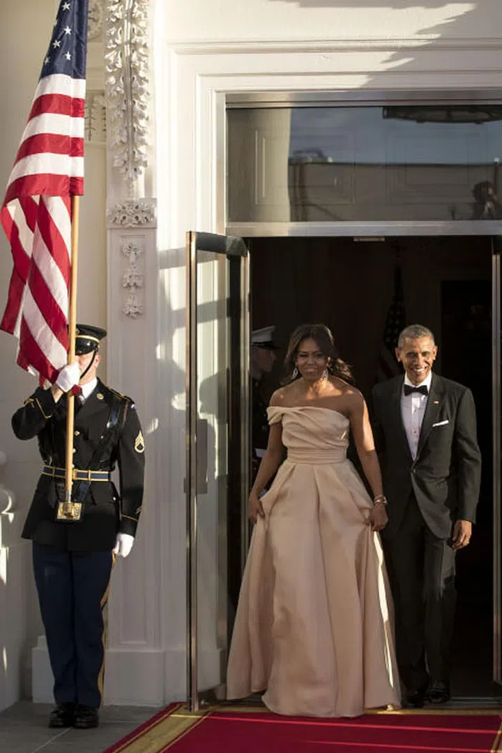 Michelle Obama again opts for a gorgeous dress by Naeem Khan, this time in a blush color with an asymmetrical neckline.