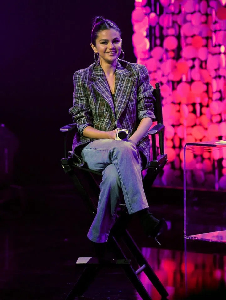 Selena Gomez goes for a street-chic look at her album release party. The singer wears a plaid blazer, brown tank top from Vince, Levi's jeans and Stuart Weitzman boots.

Photo: Getty