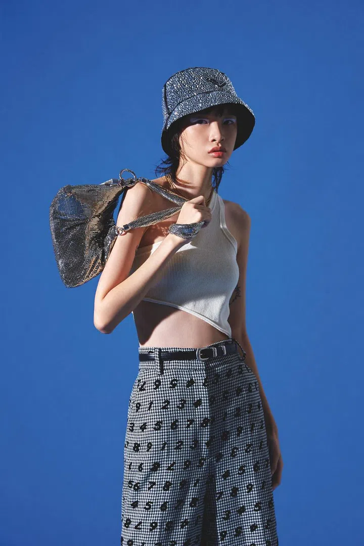 Bodysuit, and belt, both from CELINE by Hedi Slimane. Trousers, from Moschino. Hat, from Prada. Necklaces, from Dior. Bag, from Jimmy Choo. (Photo: Vee Chin)