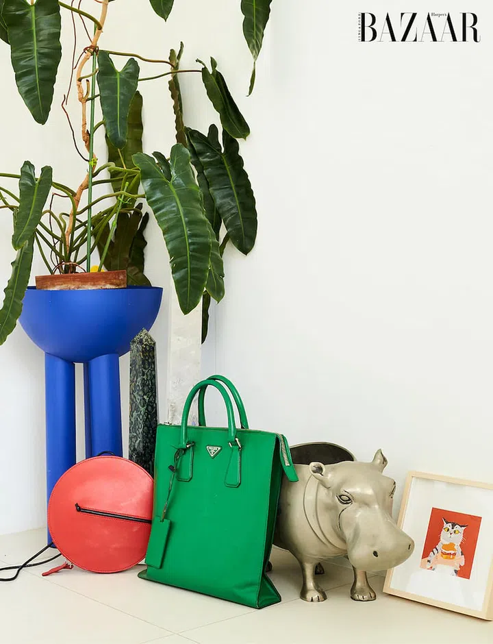 A bag by The Sleeveless Garden and a Prada top handle tote nestle among fun decor pieces.