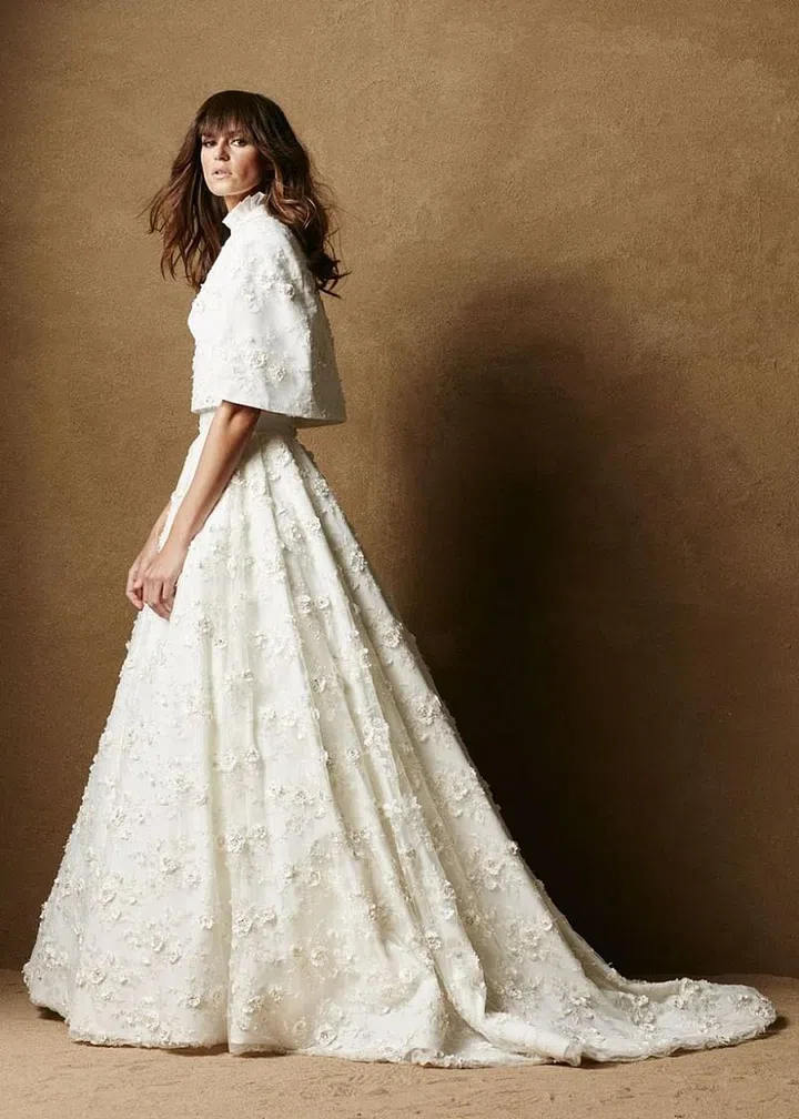 Minnesota-based Caroline Hayden knows her clientele; she launched her first collection, Fall 2016, after years of designing bespoke ready-to-wear, evening and bridal in the midwest. Her hybrid bridal-meets-RTW debut focused on three color ways in three fabrications, all of which were designed to be wrinkle-free and withstand the test of time. Separates are key to this collection's cool factor, where silhouettes gain visual interest, versatility and dimension with each added capelet, vest or pleated-collared blouse. Her smart fabrics are as intelligent as her multi-piece looks, which encourage brides to find ways to wear their special-day separates post-wedding.