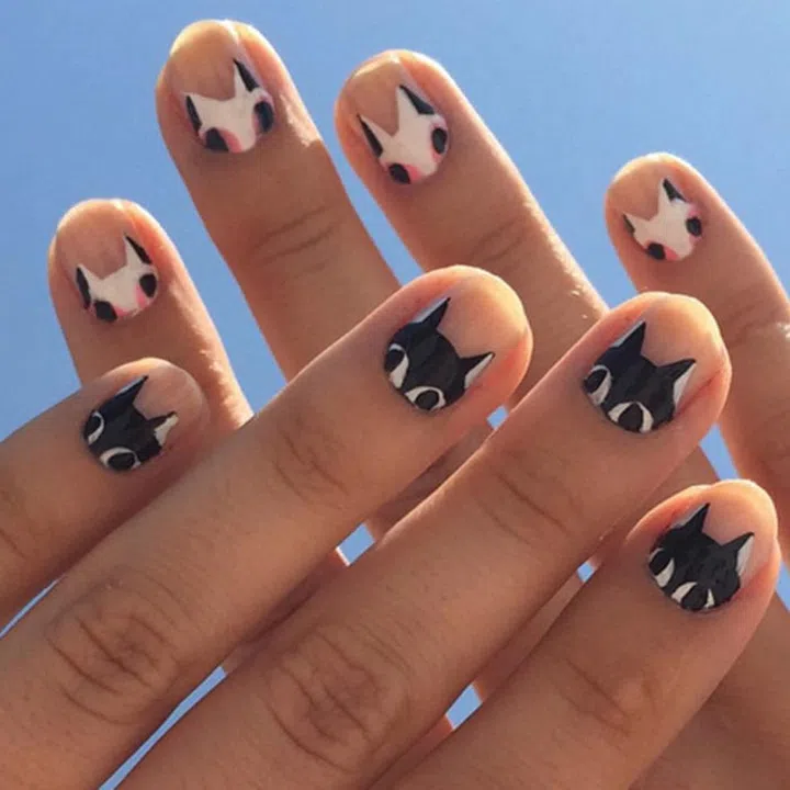 Black and white kittens peek from manicurist Jessica Washick's (@jessicawashick) cuticles. 