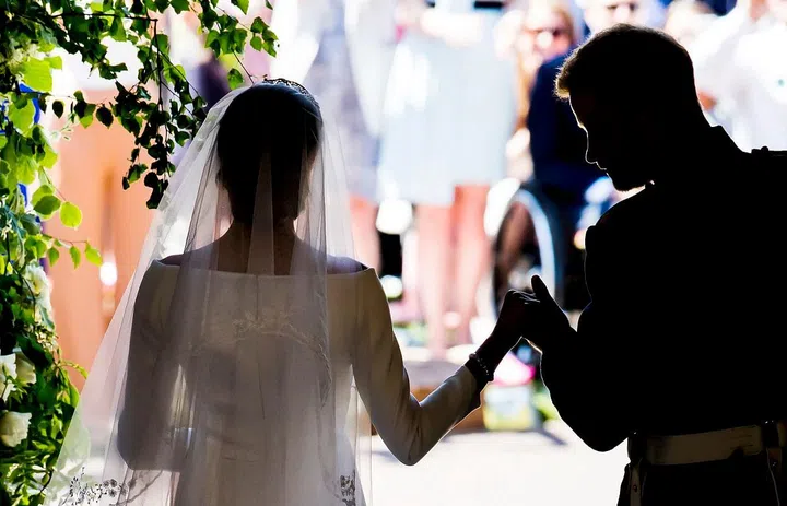 Prince Harry taking Meghan Markle's hand