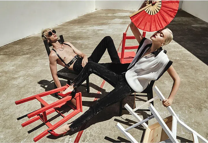(On him) Metal sunglasses, Giorgio Armani. (On her) Pleated silk blouse; denim pants; leather belt with chain; leather and snakeskin pumps, Givenchy. Metal earrings, Salvatore Ferragamo