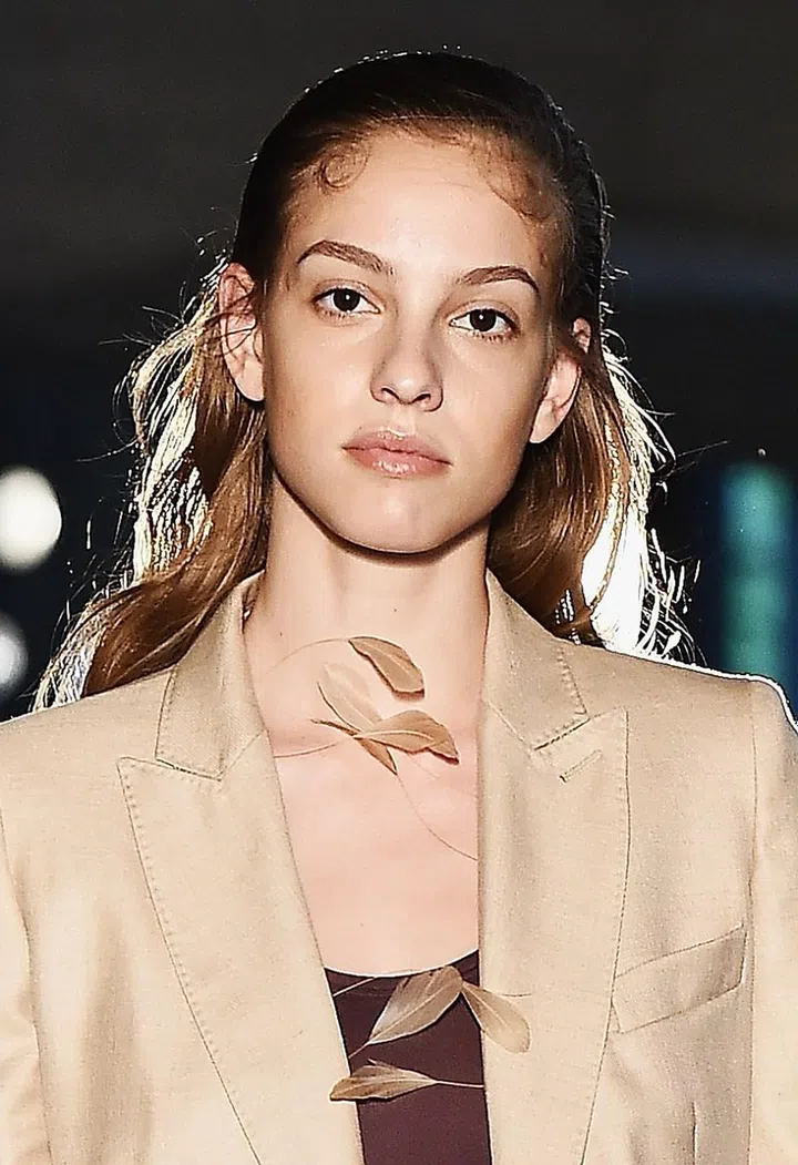 Brows are perfectly groomed and defined. Fill it in with a micro pencil to create hairlike strokes and set it down with a clear gel. Lips are kept juicy and glossy. Hair is sleeked back partially. Photo: Getty 