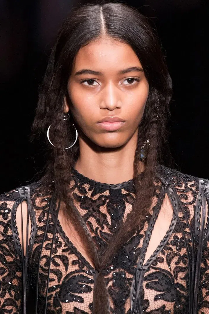 There were actually two ponytails at Alexander McQueen: one in the front and one in the back. Backstage, hairstylist Guido Palau described the long, crimped hair as both "romantic" and "witchy." He worked Redken Braid Aid 03 through the hair before using a flat iron to create the random, uneven bends. He brushed through the hair vigorously to create a fuzzy softness. It was then gathered into a low, thin ponytail under the chin and behind the back. 