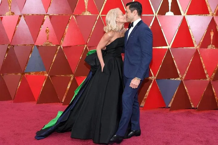 Longtime couple Kelly Pippa and Mark Conseulos are well-versed in the art of PDA. At the 90th Annual Academy Awards in 2018, the couple went in for a playful kiss. Photo: Getty
