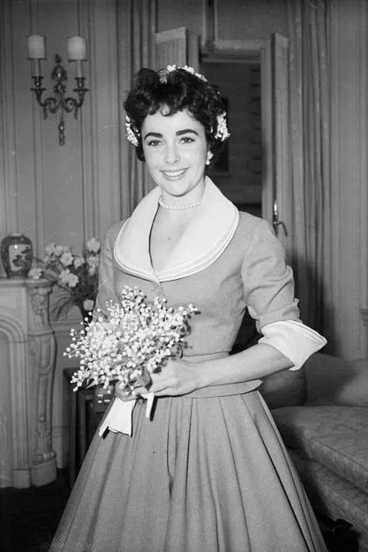 While she wore several gowns for her many marriages, Elizabeth Taylor's first unconventional dress was this simple suit for her 1952 wedding to second husband Michael Wilding. 
