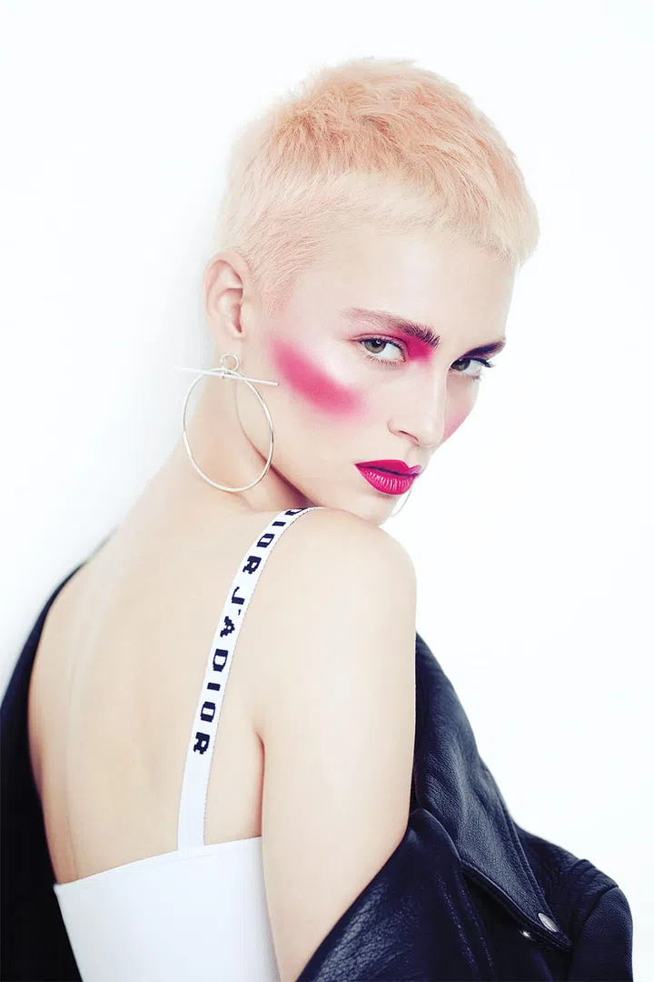 Make a statement with pops of the eye-catching hue at unexpected spots. Fuchsia applied just below the inner corners of your brows creates the illusion of deeper set eyes; using punchy pink blush instead of contour powder to sculpt your cheekbones also exudes a super cool, athletic vibe. The horizontal placement of the blusher helps balance out a wide forehead by making your jawline appear more angular—perfect for those with a heart-shaped face. Using an angled cheek brush, apply M.A.C’s Powder Blush in Full Fuchsia just beneath your cheekbones and blend towards the ears. Don’t forget to complement your look with Givenchy’s Le Rouge in 205 
Fuchsia Irrésistible. 

Earrings, Hermès. Jacket, 
stylist’s own. Top, Dior