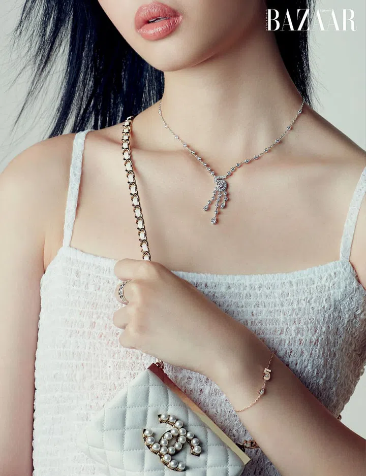 White gold and diamonds Eternal N°5 necklace; Beige gold and diamond Extrait de N°5 bracelet; white gold, and Beige gold and diamond Coco Crush mini rings, Chanel. Dress; bag, Chanel.