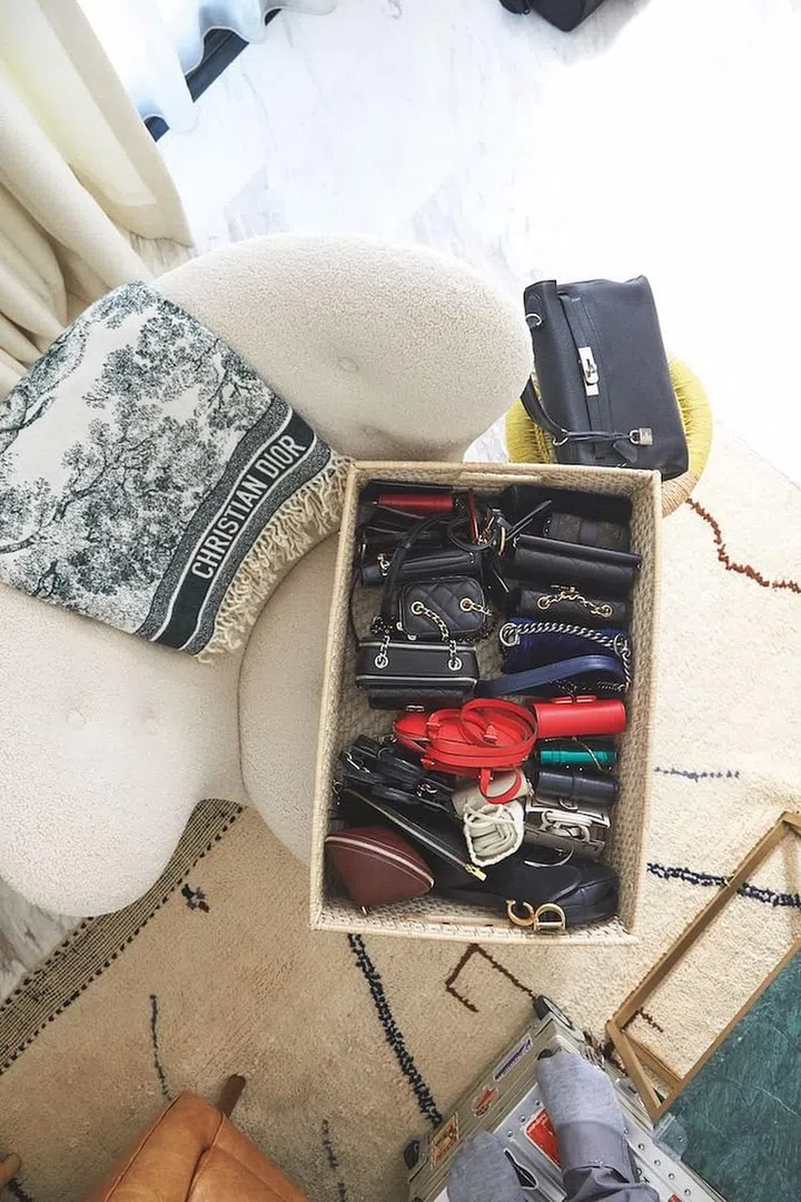 Cao’s collection of mini bags and a Dior throw on a cream armchair atop a rug she purchased in Marrakech.