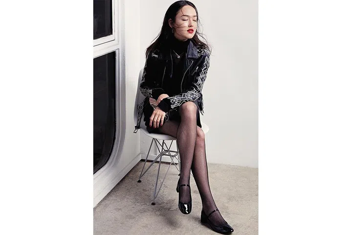 Embroidered leather jacket, NIKKIE. Silk and knot turtleneck jumper, Roland Mouret at The Outnet. Leather skirt, Longchamp. Leather and glitter bag, Furla. Metal and crystal earrings, Atelier Swarovski. Leather Mary Janes, Repetto