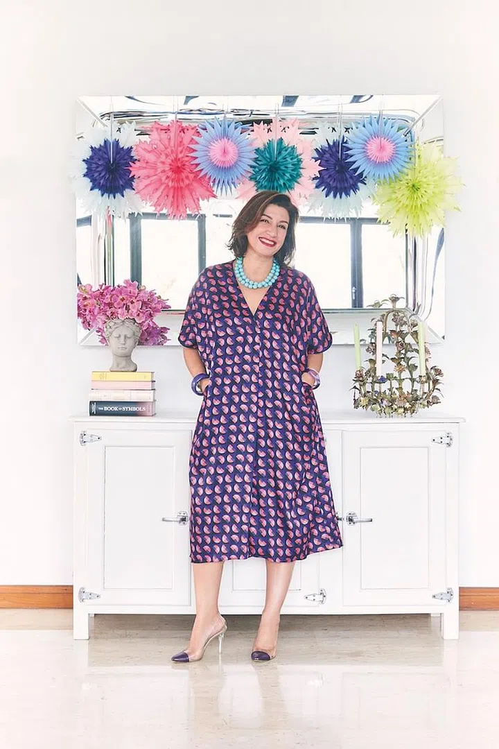 Cameron, in her own ZARA dress, Paul Smith pumps and colour pop accessories, in front
of a Philippe Starck mirror and a cabinet inspired by vintage refrigerators, which she decorated with paper snowflakes,
and a Hellenic vase and an old chandelier respectively. (Photo: Veronica Tay)