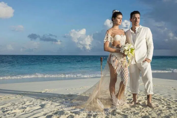August 2016 Former Victoria's Secret model Isabeli Fontana married Brazilian musician Diego Ferrero on a private island in the Maldives wearing a sheer, embellished Água de Coco gown over a cream bikini.
